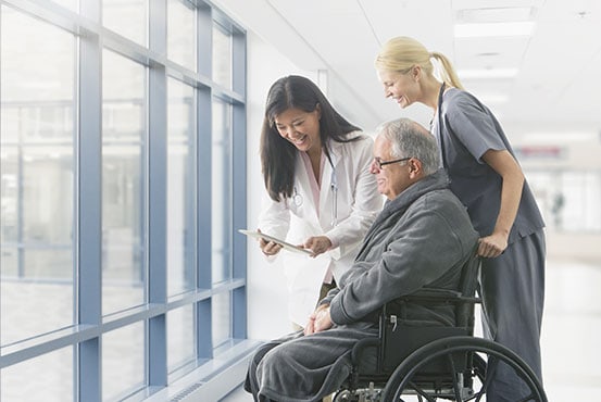 Medical staff helping an elderly man