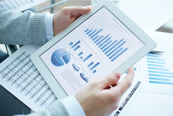 Hands Holding a Tablet with Analytics Charts